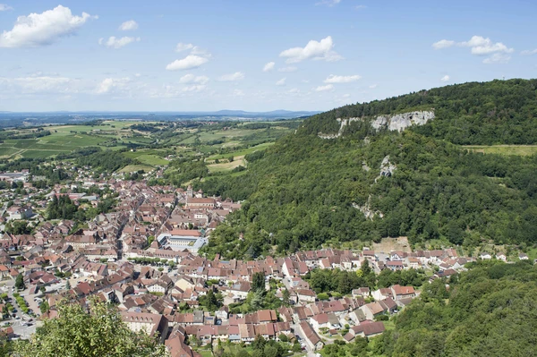 Photographie réelle de la ville de Poligny prise en vue panoramique ou aérienne, montrant le paysage urbain caractéristique de cette commune jurassienne avec ses bâtiments historiques et modernes, ses rues et son environnement, représentant clairement une zone d'intervention majeure de MGEP. Image en lumière naturelle, professionnelle et clairement identifiable comme Poligny, illustrant l'une des principales villes couvertes par le rayon de 50 km de l'entreprise.